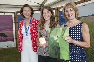 Mairi Eyres (centre) is presented with the 16-and-under Julian Gardner Memorial Trophy for her beetle photograph by Julian’s sister Anna Murphy (right) and the GWCT’s Teresa Dent (left). Photocredit: Jon Farmer