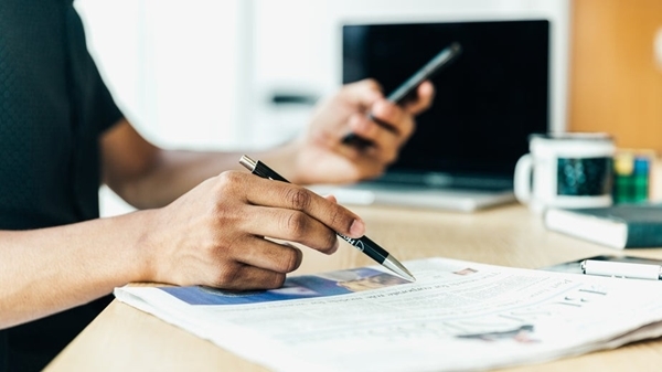 Man -at -desk -looking -at -his -newspaper Man -at -desk -looking -at -his -newspaper