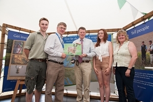 Graham Dixon with his family from Hexham, Northumberland was a runner-up in the adult category for his racing hare image. Graham (second left) is pictured with Richard Benyon (centre) and his brown hare image